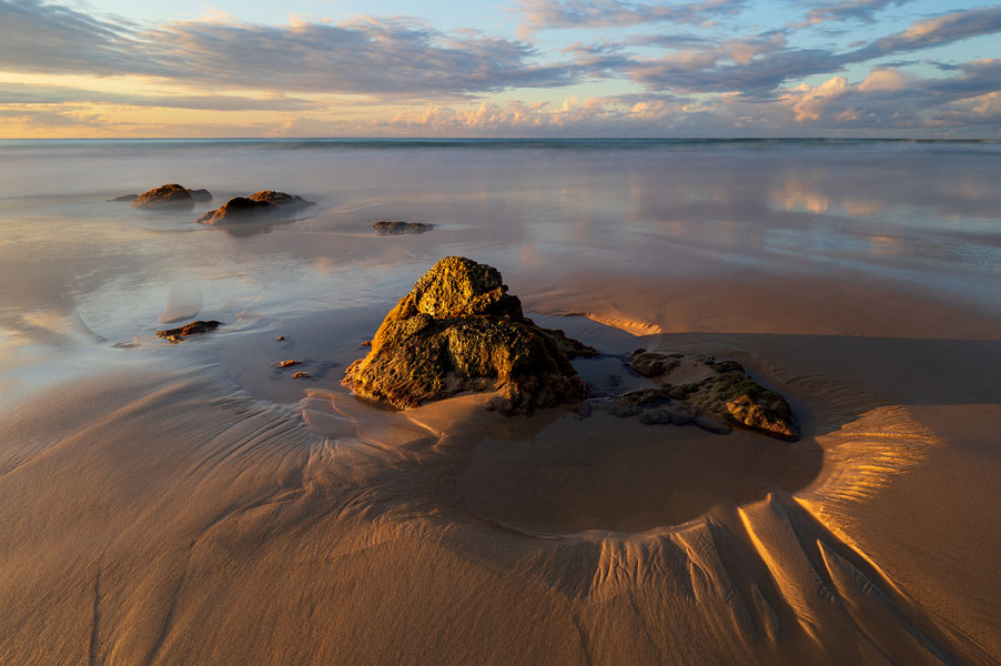 Low tide exposing beach and rock formations